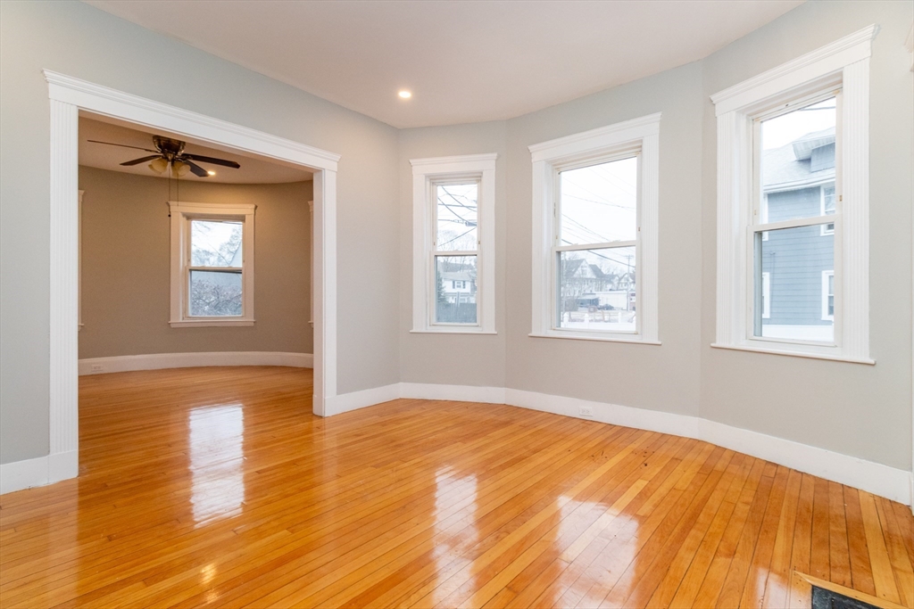 168 Brook Road Milton, MA 02186 - Photo 5 of 25 a view of an empty room with wooden floor and a window