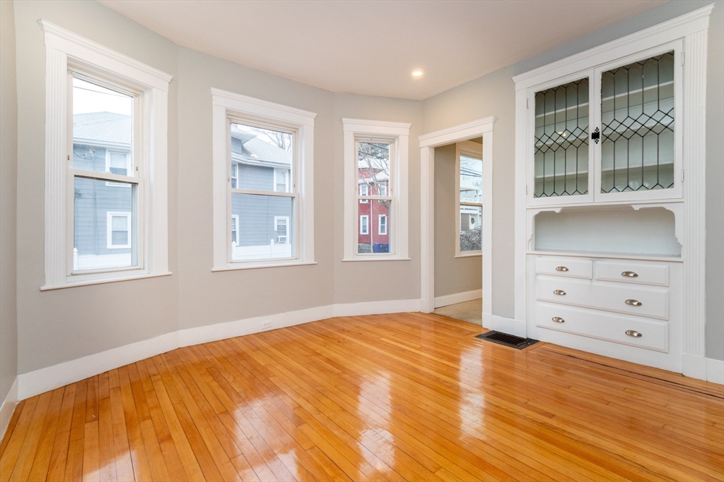 168 Brook Road Milton, MA 02186 - Photo 6 of 25 a view of an empty room with window and wooden floor