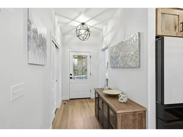 a kitchen with a refrigerator and a wooden floor
