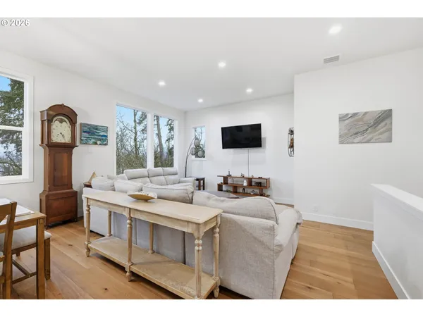 a living room with furniture a flat screen tv and a window