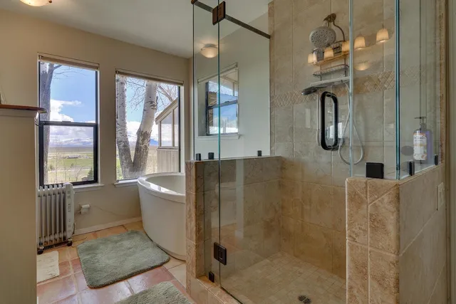 a bathroom with a glass shower door and a glass door