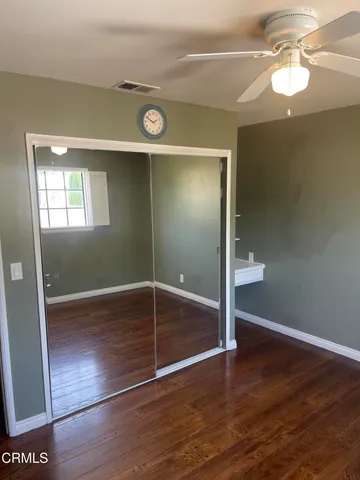a view of empty room with wooden floor and fireplace