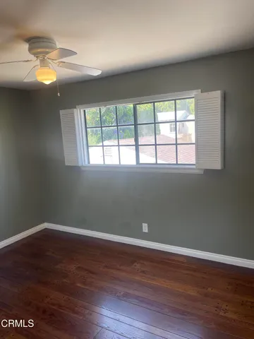 a view of empty room with wooden floor and fireplace