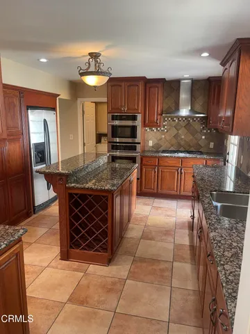 an empty room with wooden floor fireplace and windows