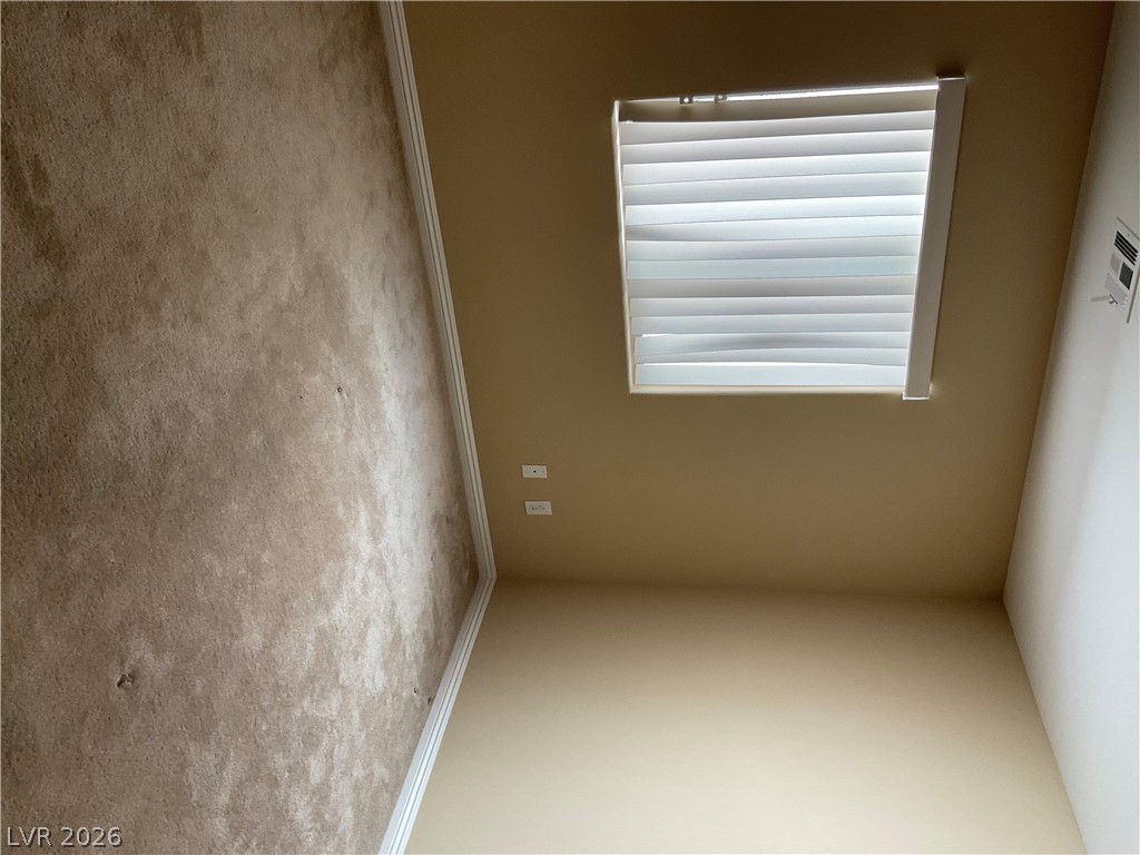 12 Jasmine Point Street Henderson, NV 89074 - Photo 4 of 15 Natural light filters through horizontal blinds into this cozy, carpeted interior.