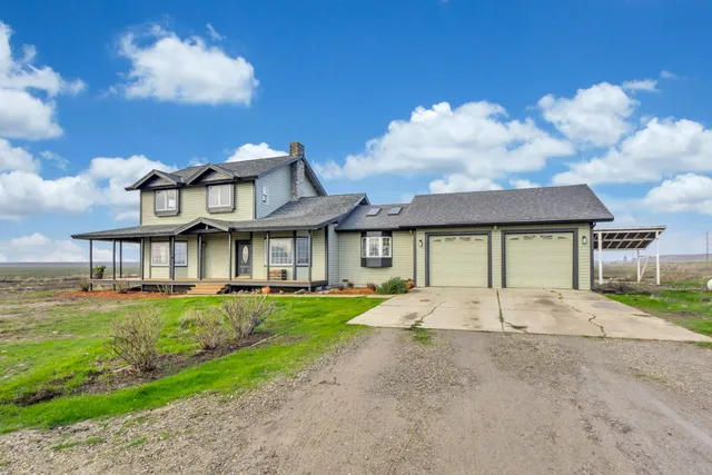 a view of a big house with a big yard and large trees