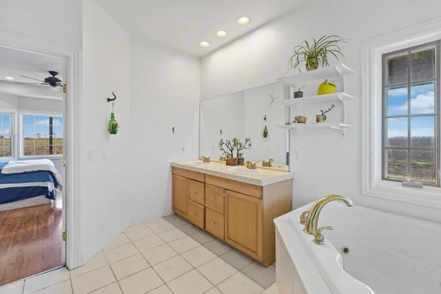 a bathroom with a tub sink and mirror