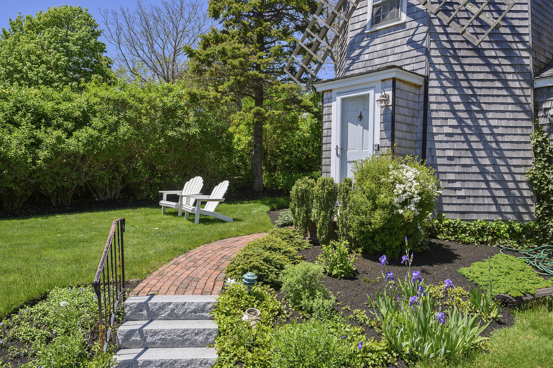 133 Queen Anne Road Chatham, MA 02633 - Photo 36 of 52 a front view of a house with a yard table and chairs