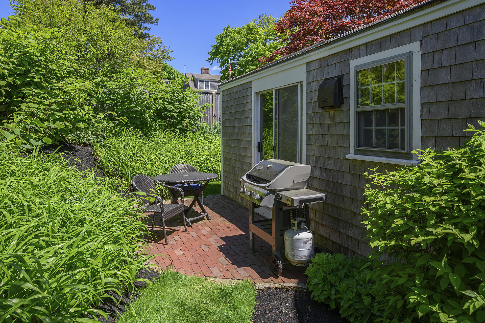 133 Queen Anne Road Chatham, MA 02633 - Photo 38 of 52 a view of a chair and table in backyard of the house