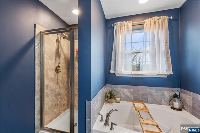 a bathroom with a tub sink and shower