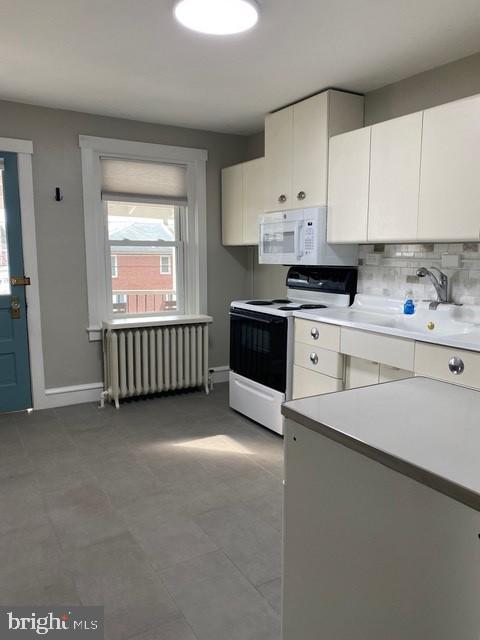 112 North Miller Street, Unit 2 Reading, PA 19607 - Photo 4 of 24 a kitchen with stainless steel appliances granite countertop a stove a sink and white cabinets