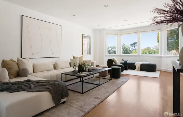 a living room with furniture potted plant and a large window