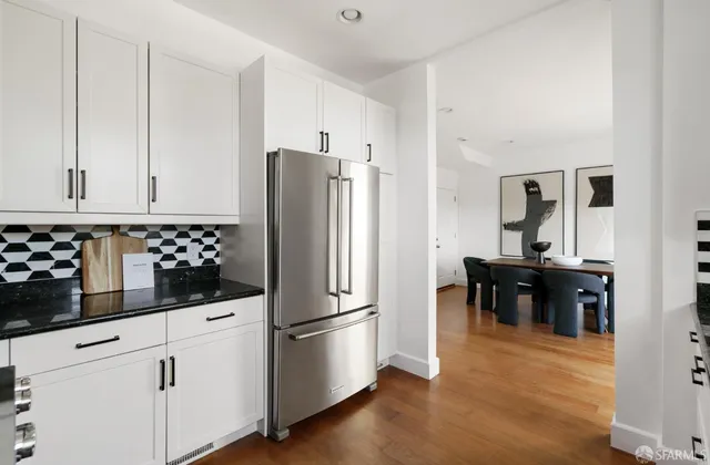 a kitchen with granite countertop a refrigerator and a stove top oven