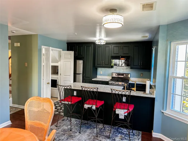 a kitchen with stainless steel appliances granite countertop a stove a refrigerator and a wooden cabinets