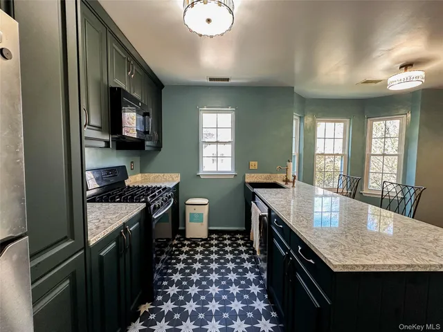a kitchen with stainless steel appliances granite countertop a sink stove and cabinets