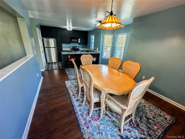 a dining room with furniture a chandelier and wooden floor