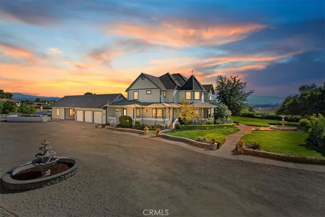 a front view of a house with a garden and yard