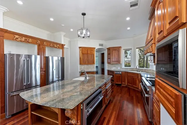 an open kitchen with sink and refrigerator