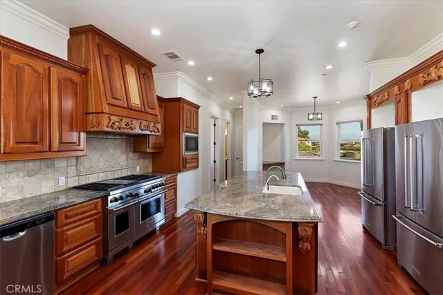 a kitchen with stainless steel appliances granite countertop wooden floors and stove