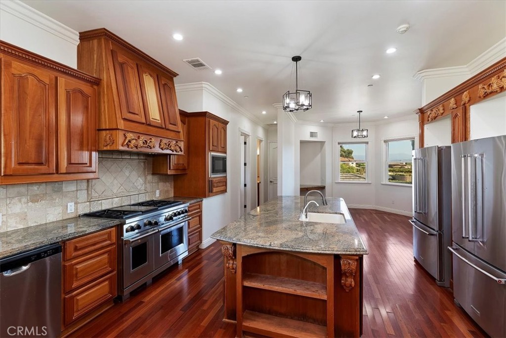 39650 Patagonia Court Temecula, CA 92591 - Photo 12 of 55 a kitchen with stainless steel appliances granite countertop wooden floors and stove