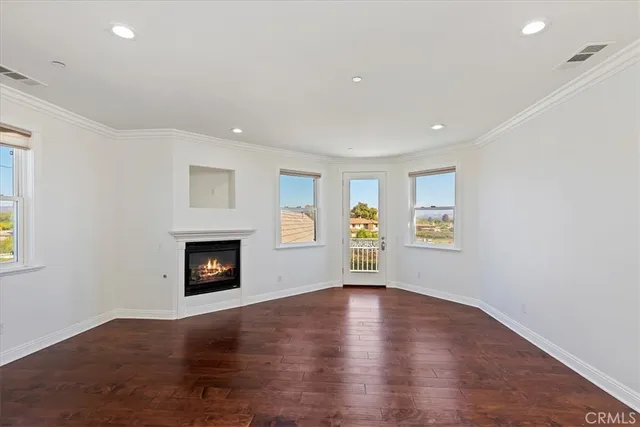 an empty room with windows and fireplace