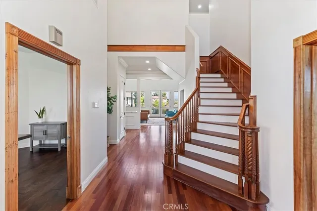 a view of a hallway with wooden floor and stairs