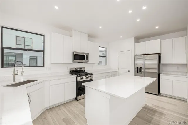 a kitchen with stainless steel appliances a sink stove and refrigerator