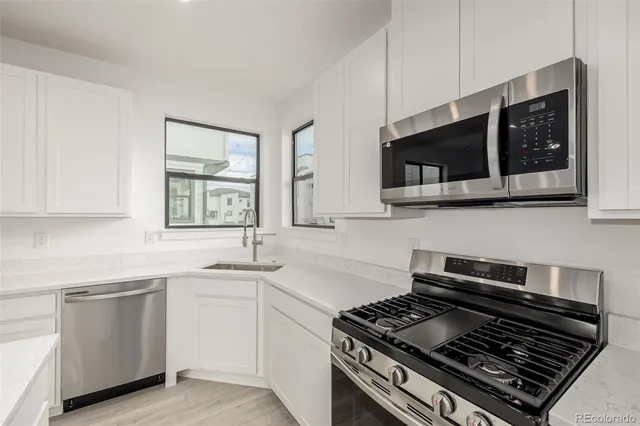 a kitchen with stainless steel appliances kitchen island a stove and a microwave