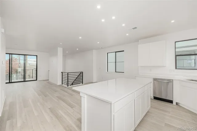 a view of an empty room with windows and cabinet