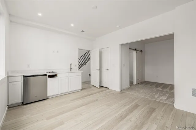 a view of a sink and dishwasher with wooden floor