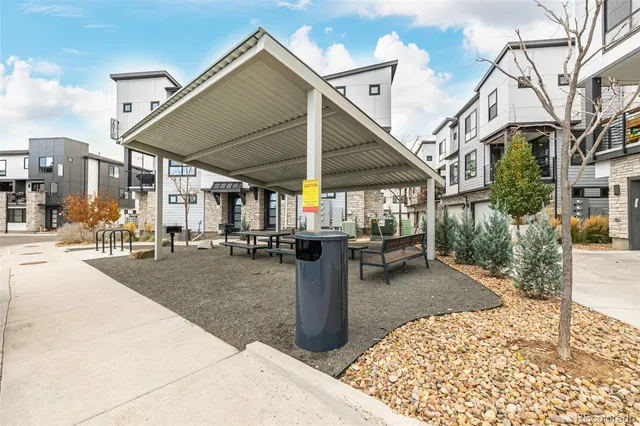 a view of a patio with table and chairs and a barbeque
