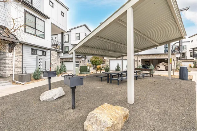 a view of a patio with table and chairs a barbeque with the view of the trees