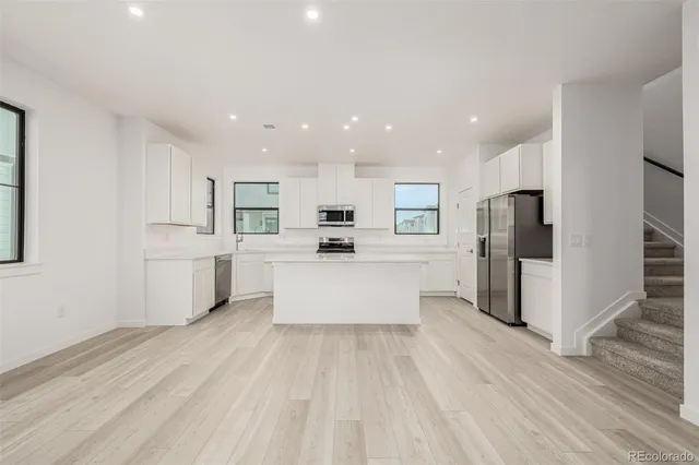 a large kitchen with a center island and stainless steel appliances