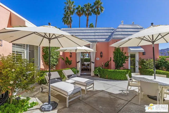 a view of a patio with table and chairs under an umbrella
