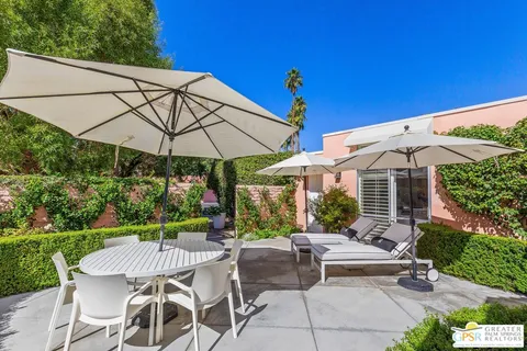 a view of a patio with a table and chairs under an umbrella