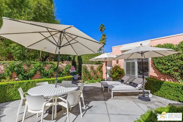 a view of a patio with a table and chairs under an umbrella