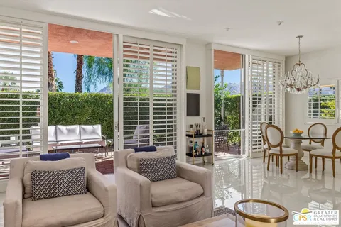 a dining room with wooden floor and chandelier