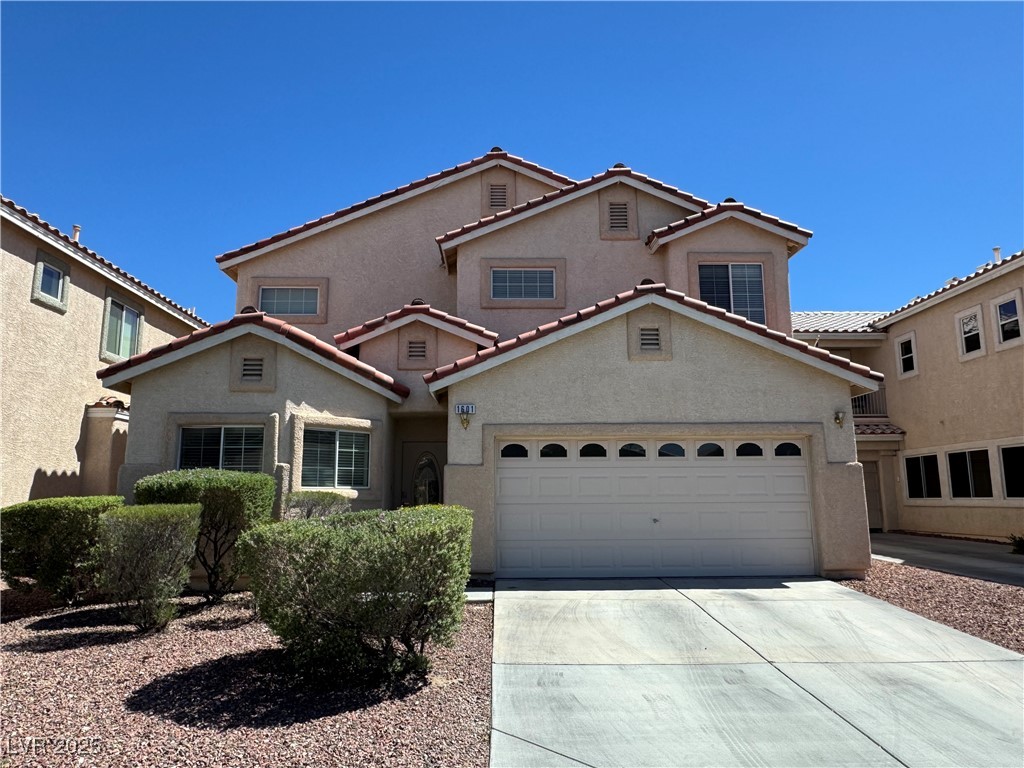 Mediterranean / spanish-style home with stucco siding, driveway, and a garage