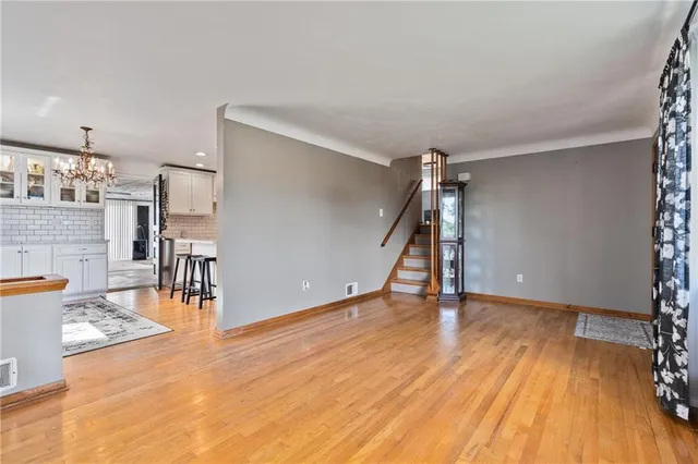 a view of empty room with wooden floor and stairs
