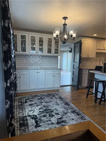 a view of a kitchen with kitchen island granite countertop wooden floor and a refrigerator