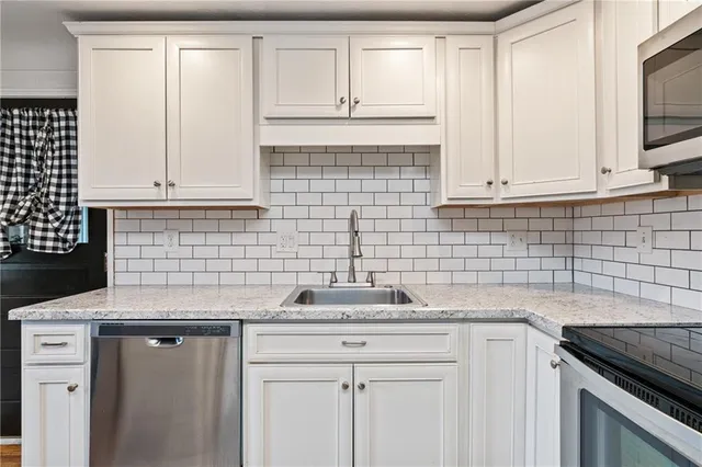 a kitchen with white cabinets and a sink