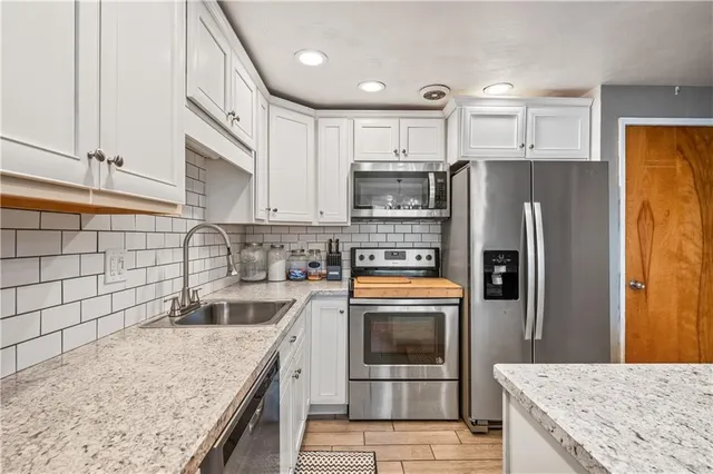 a kitchen with stainless steel appliances granite countertop a sink stove and refrigerator