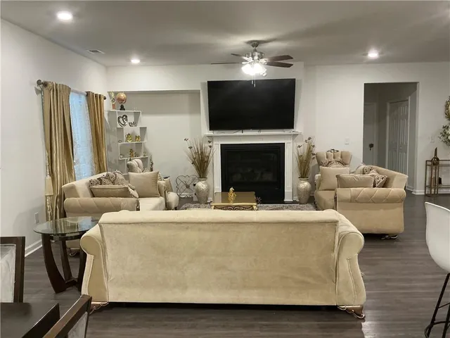 a living room with furniture a fireplace and a flat screen tv