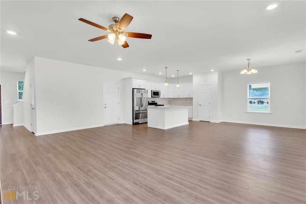 860 North Bethany Road McDonough, GA 30252 - Photo 22 of 57 a view of an empty room with wooden floor and a ceiling fan
