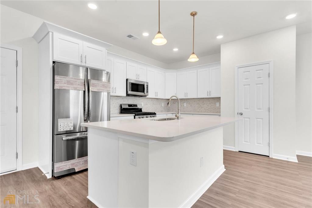 860 North Bethany Road McDonough, GA 30252 - Photo 27 of 57 a kitchen with kitchen island a sink stainless steel appliances and cabinets