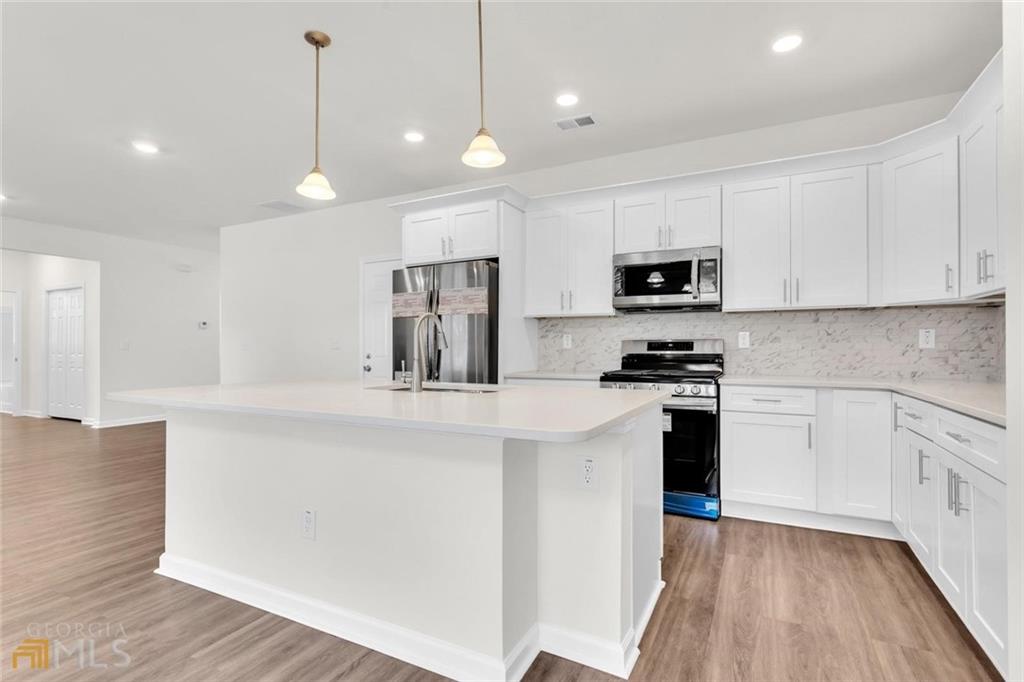 860 North Bethany Road McDonough, GA 30252 - Photo 28 of 57 a kitchen with kitchen island white cabinets and stainless steel appliances
