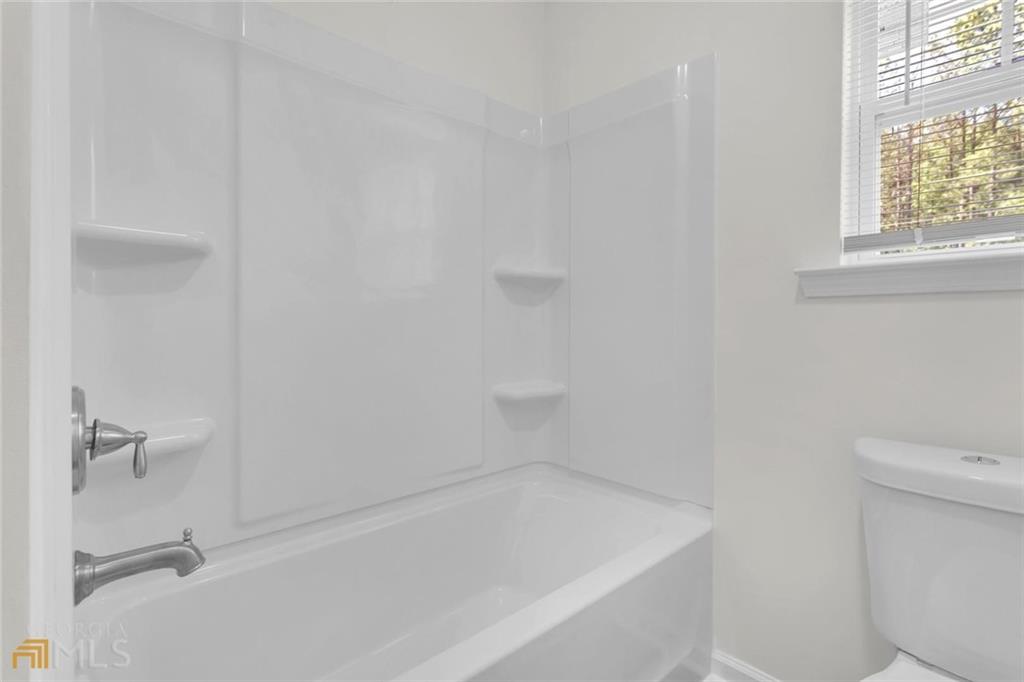 860 North Bethany Road McDonough, GA 30252 - Photo 45 of 57 a bath tub sitting next to a white toilet and a window