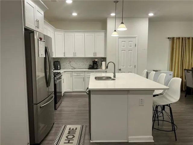 a kitchen with a sink stainless steel appliances and white cabinets