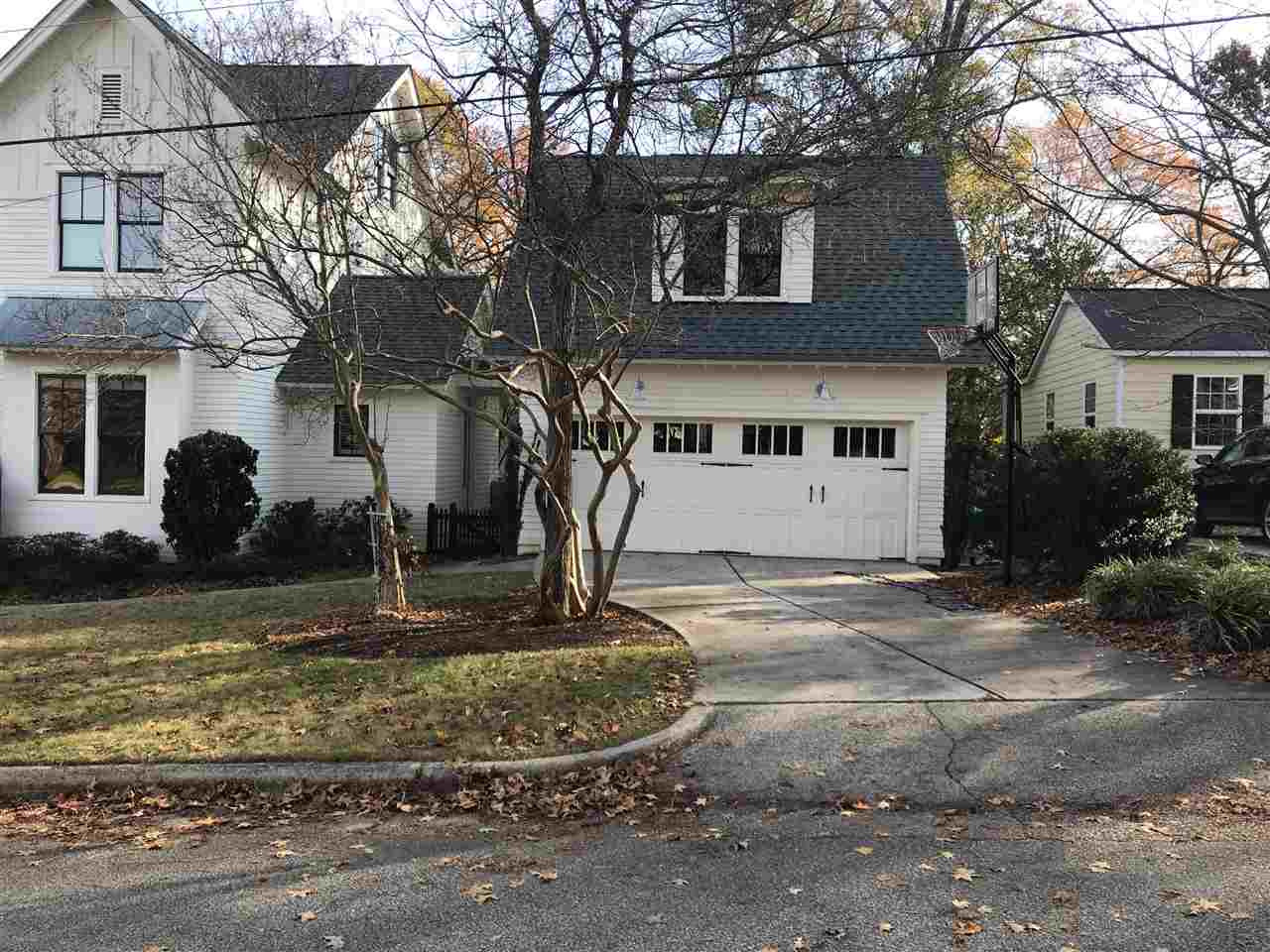 2100 Wiggs Street Raleigh, NC 27608 - Photo 3 of 3 a view of a white house with a yard plants and large tree