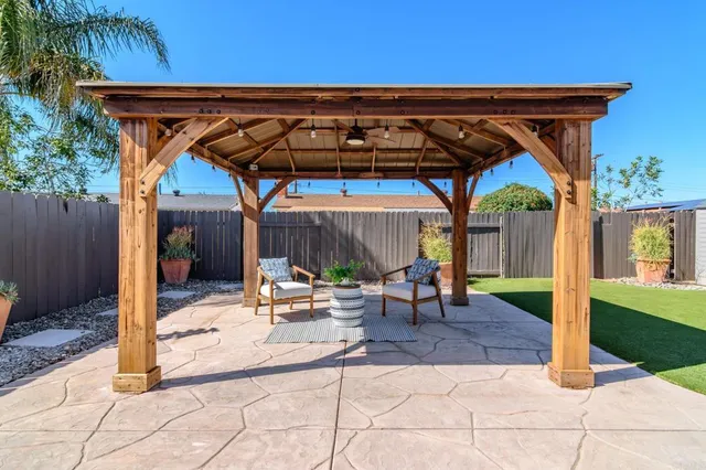 a view of backyard with barbeque grill and a wooden fence
